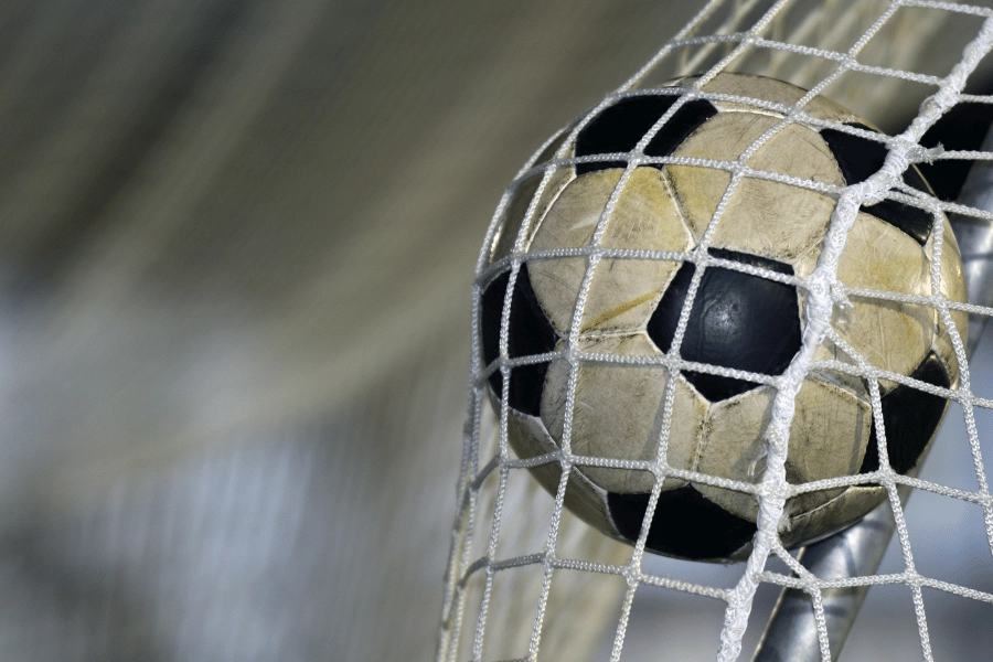 soccer ball kicked in the net on a soccer field