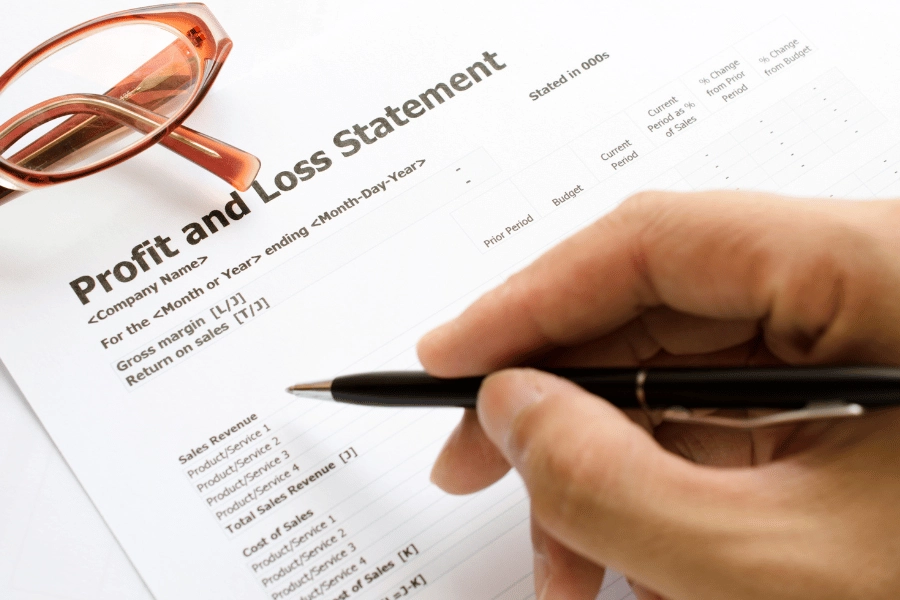 filling out a profit and loss statement with a pen