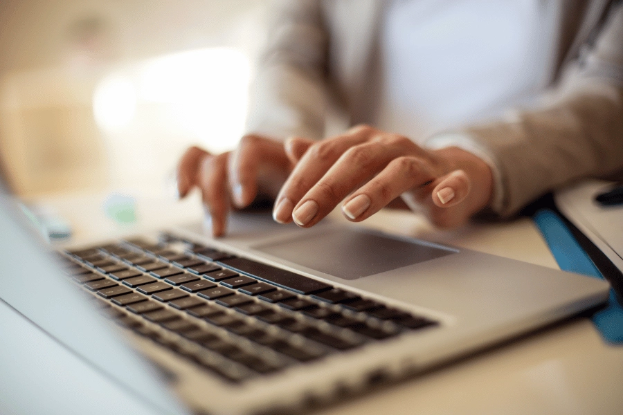 woman working on laptop computer and typing on keypad