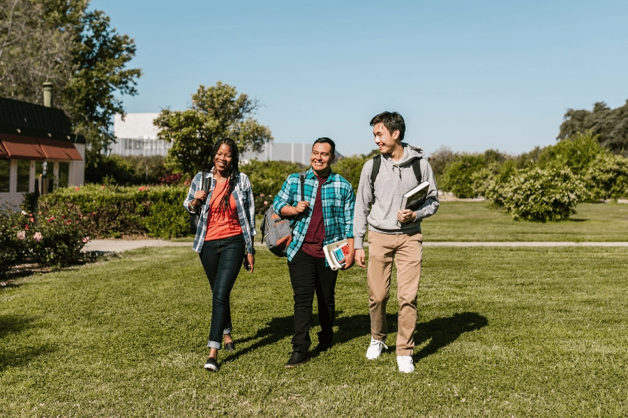 college students walking on campus and holding books