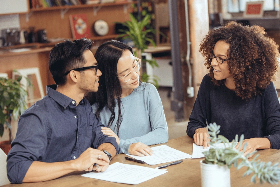 two homeowners closing on a home and signing paperwork