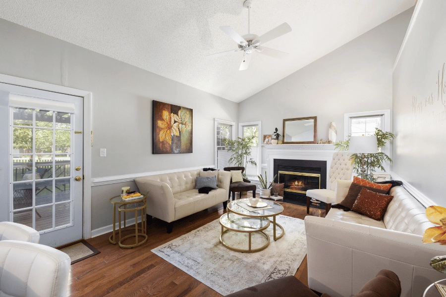 beautifully staged living room with white couches and fireplace