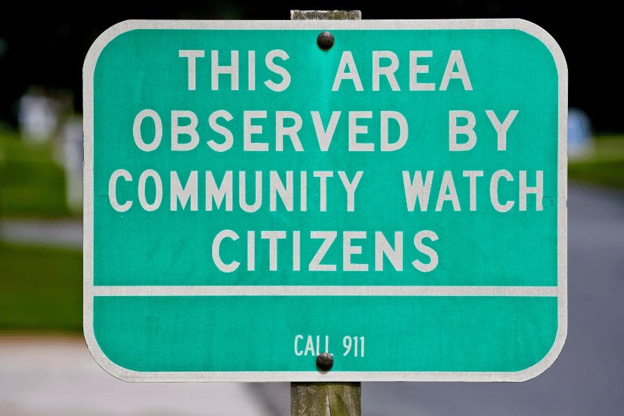green neighborhood watch street sign in a neighborhood