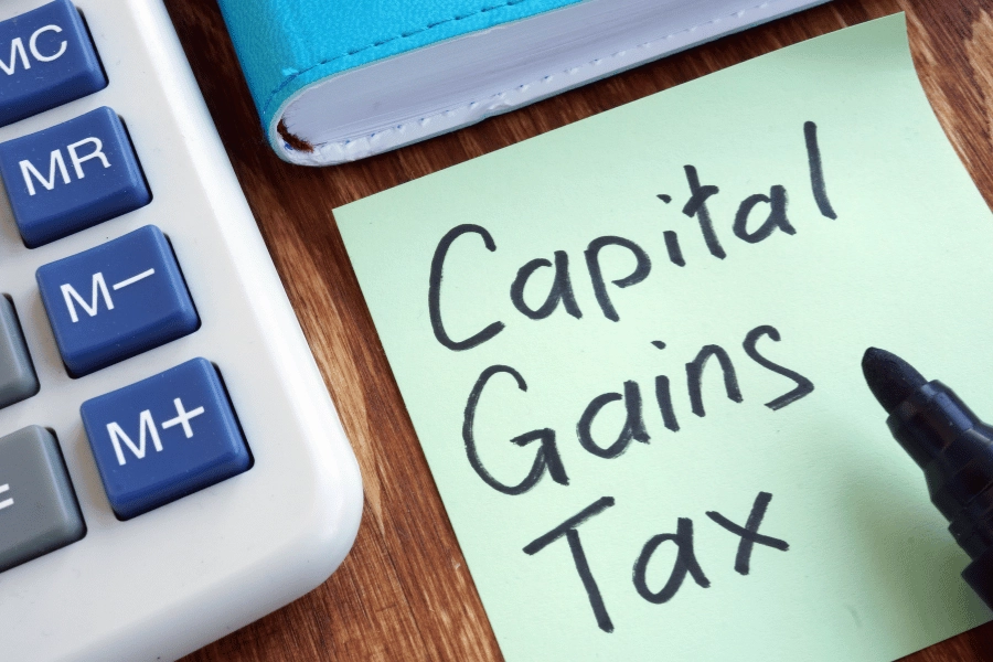 capital gains taxes in sharpie written on a green sticky note