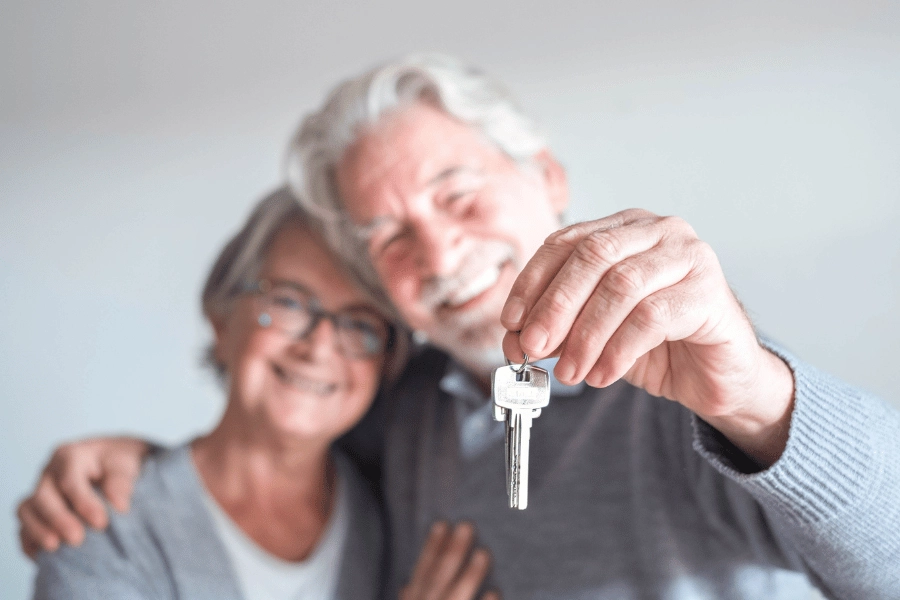 retired couple holding house keys 