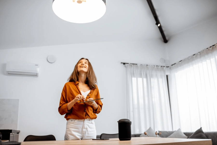 woman in an orange shirt using a voice control smart home system