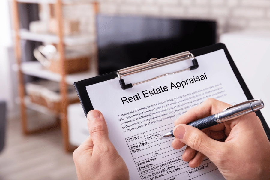 filling out a home appraisal form with a pen on a clipboard