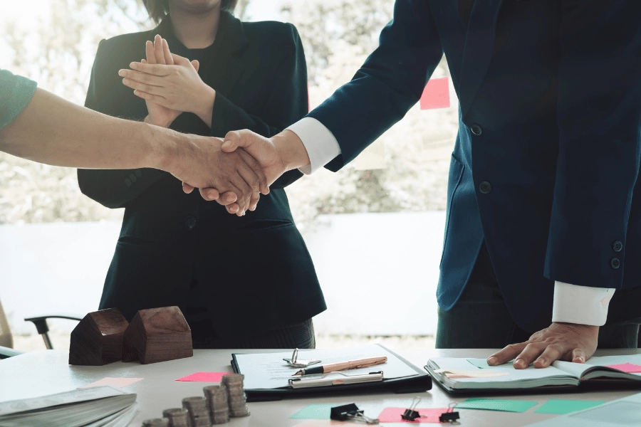 client shaking hands with a real estate agent wearing a suit
