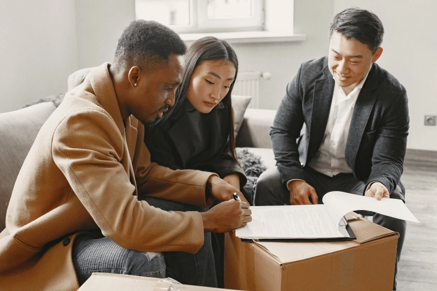 homebuyers signing papers with a real estate agent and completing a real estate transaction