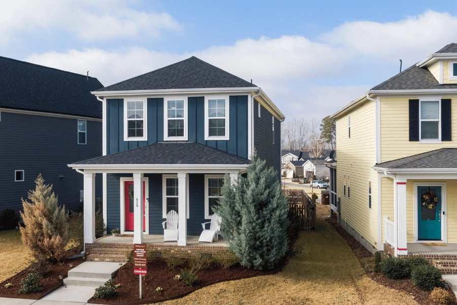 cute blue house in a residential neighborhood with red front door and front porch