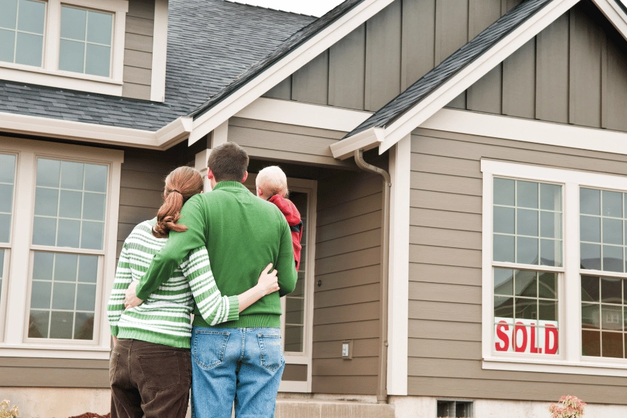family of three looking at their new single-family home 