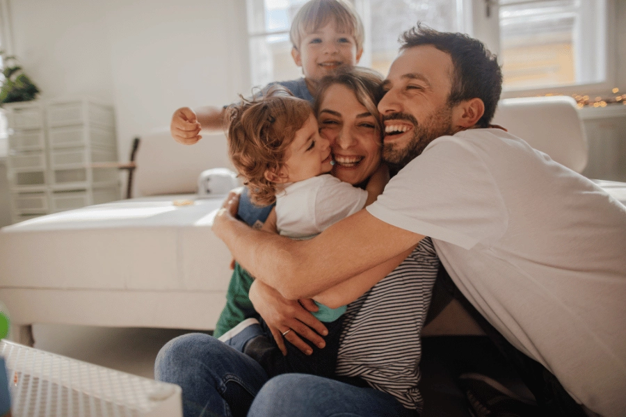 happy family at home hugging on the floor and laughing