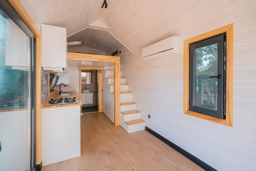inside of a tiny home with stairs, kitchen, and bathroom