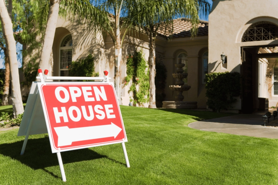 red open house sign pointing to a beautiful single-family home