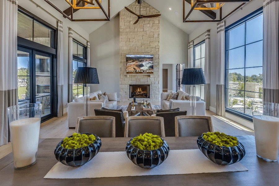 beautiful great room with nice furniture, stone fireplace, and high ceilings