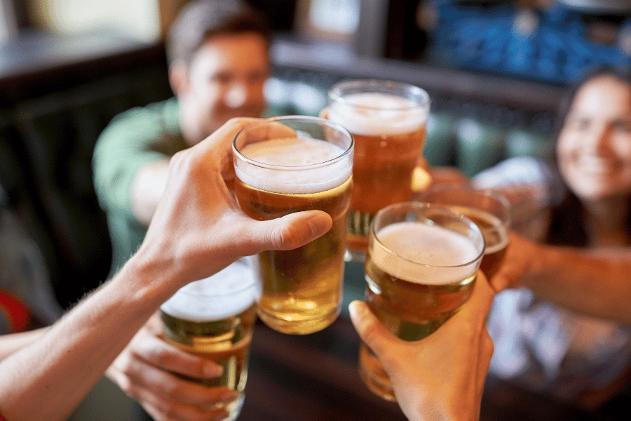 group of friends drinking beer together at a bar