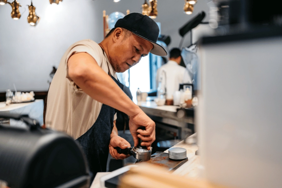 barista making espresso at a coffee shop 