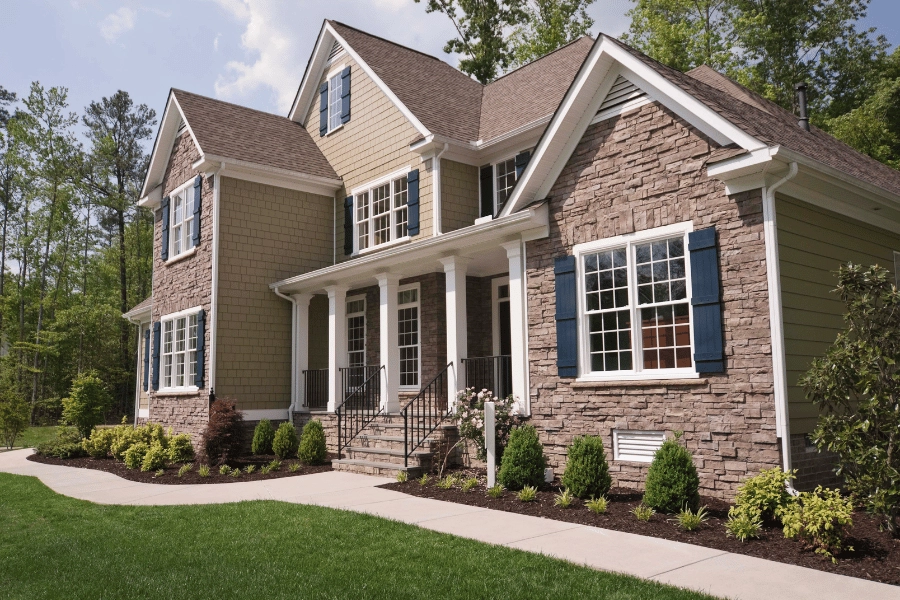 large suburban single-family home with stone and blue shutters