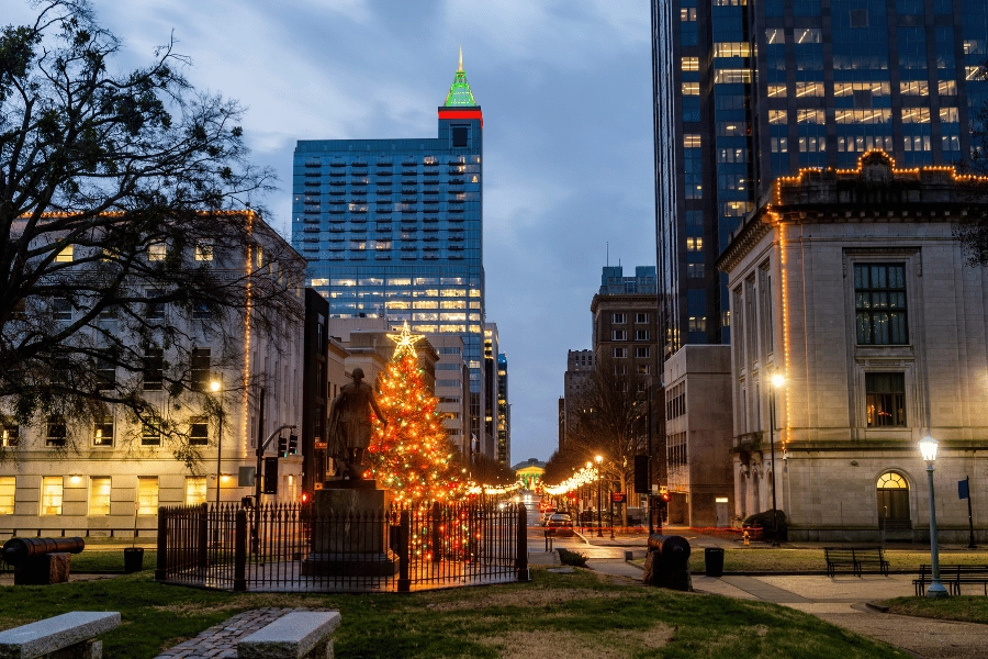 Brightly lit Christmas tree with star in Downtown Raleigh in front of the capitol building