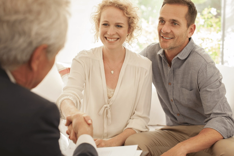 realtor working with clients and shaking their hands