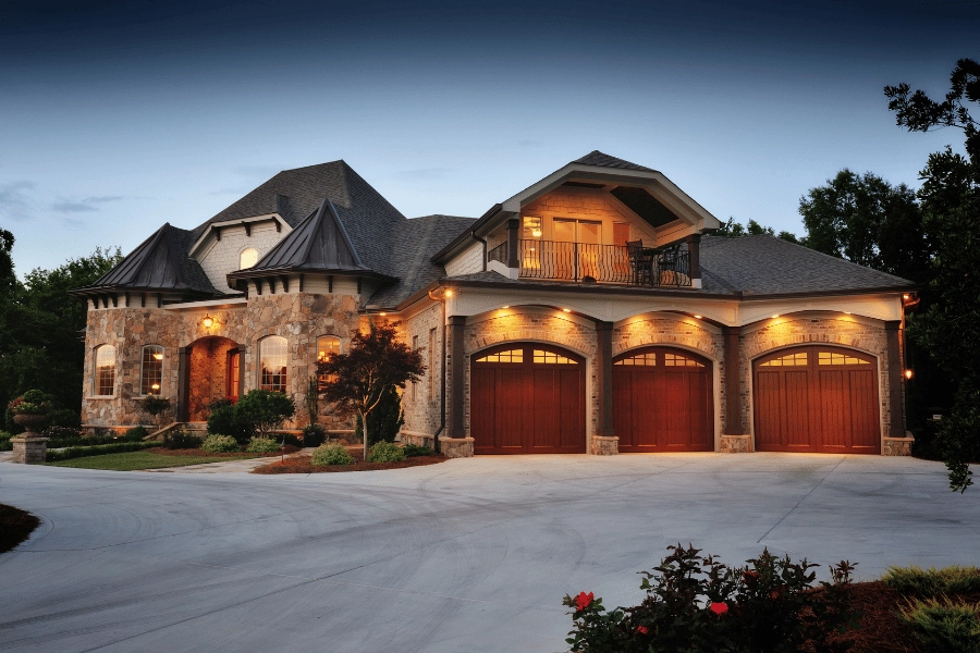 large stone luxury home with three car garages