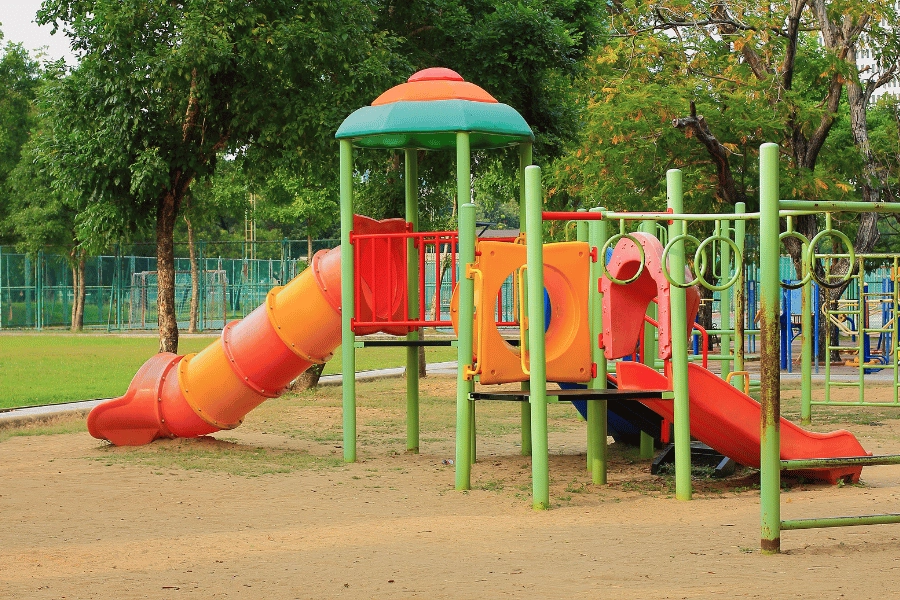 green and red playground with slide at a public park