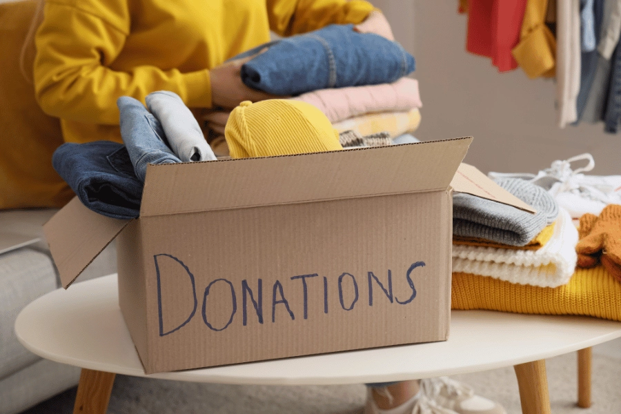 sorting through clothing and other items and putting them in a donation box